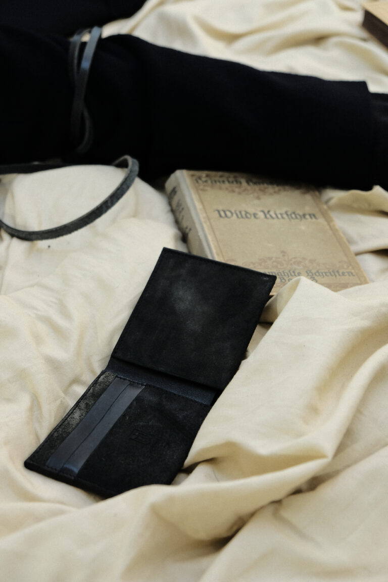 Wallet Charta liegt auf Stoff und neben einem alten Buch