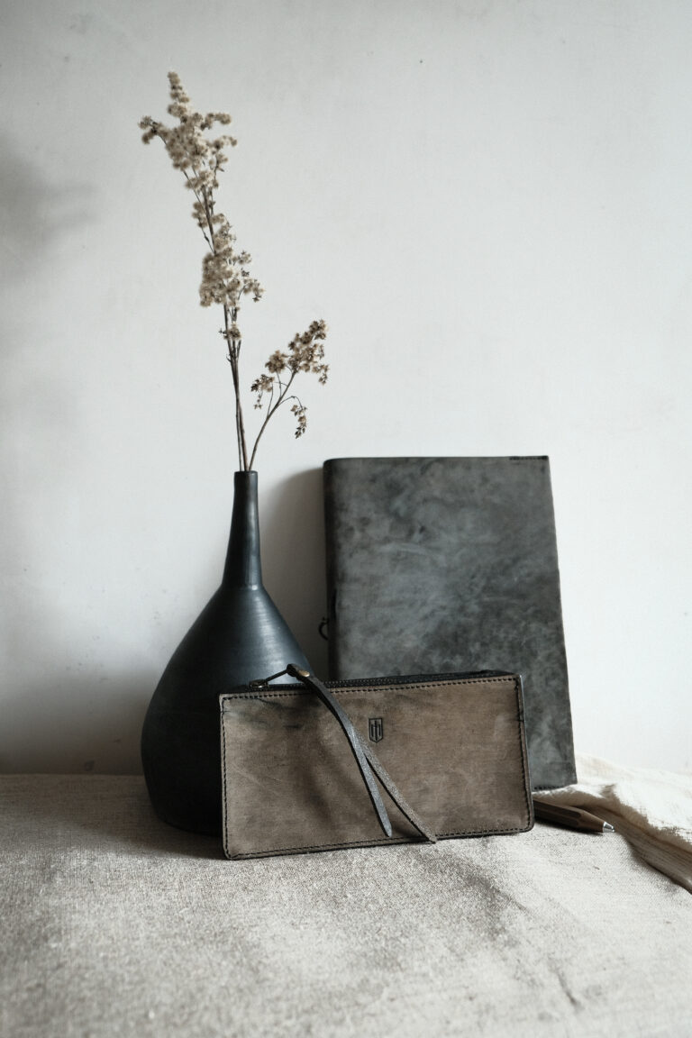 notebook cover - scribere and loculus bag from Monolar, side by side next to a vase with dried flowers.